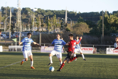 Un jugador de l’EFAC dispara a porta davant de dos rivals en una jugada del partit.