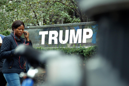 Una mujer pasa junto a un edificio propiedad del candidato republicano, Donald Trump, en Nueva York.