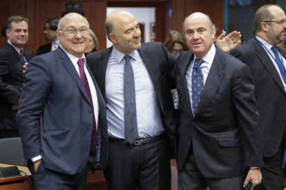 Moscovici saluda Luis de Guindos i el ministre francès de Finances durant la reunió de l’Eurogrup.
