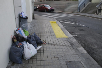 Bolsas de basura apiladas ayer en la calle Lluís Roca, en el lugar donde antes había un contenedor.