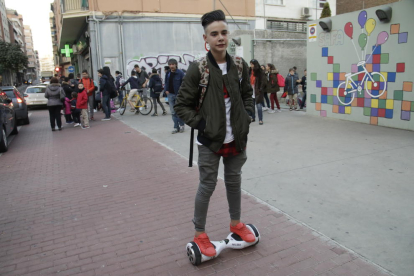 Un joven con un patinete eléctrico a la salida del colegio Sagrada Família de Lleida.