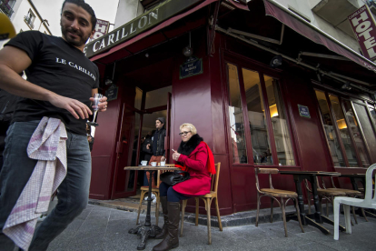 Una dona pren cafè a la terrassa de Le Carillon, un dels locals atacats a París.
