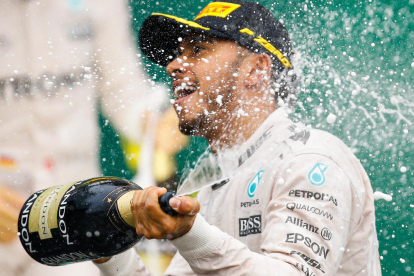 Lewis Hamilton celebra con una botella de champán su novena victoria de la temporada.