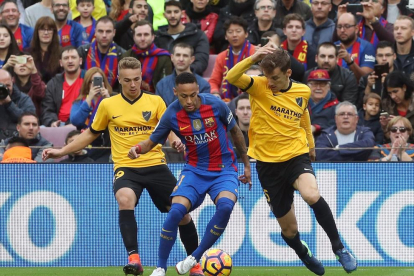 Neymar intenta avanzar con el balón ante los andaluces Javier Ontiveros y Diego Llorente.