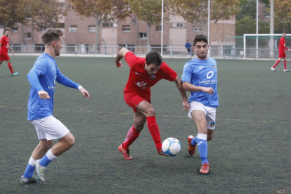 El jugador del Alpicat Padrones controla el balón ante dos jugadores del Lleida B.