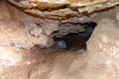 L’accés a la cova, amb restes de brossa que hi dificulten l’accés.