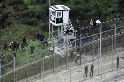 Algunos de los inmigrantes mientras saltan la valla del perímetro fronterizo con Ceuta.