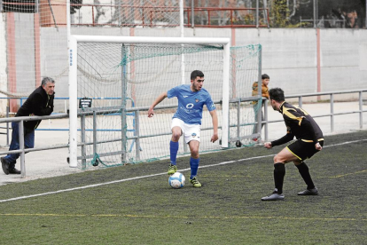 Un jugador del Lleida B controla la pilota sota l’atenta mirada d’un futbolista rival. 