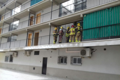 Bomberos en el balcón de la vivienda.