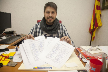 Eduard Piera muestra las firmas que han recogido.