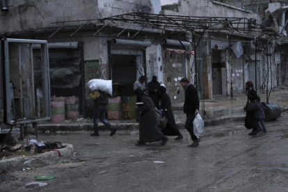 Varias personas caminan por las calles de Alepo en zona aún controlada por los rebeldes.