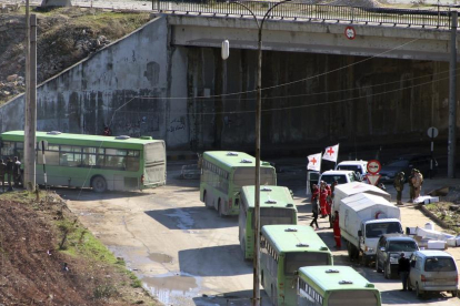 Varios operarios de autobuses esperan a comenzar la evacuación de los combatientes en Alepo.