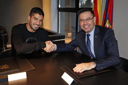 Luis Suárez, al costat del president Josep Maria Bartomeu, després de la firma de la renovació fins al 2021.
