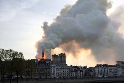 El fuego hunde la aguja y parte de la cubierta de la emblemática catedral de París.