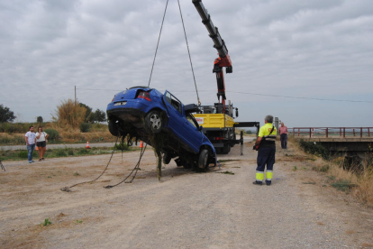 La grúa con el vehículo de las víctimas tras sacarlo del canal cerca del lugar donde cayeron al agua ayer en Bell-lloc. 