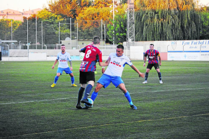 Una pugna entre dos futbolistes, ahir durant el partit al Municipal de Mollerussa.