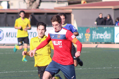 El local Genís persegueix un jugador de l’EFAC Almacelles, que juga la pilota a prop del centre del camp.