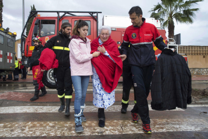 Diversos militars de la Unitat Militar d’Emergència (UME) traslladen una dona rescatada de la seua casa inundada a Los Alcázares, Múrcia.
