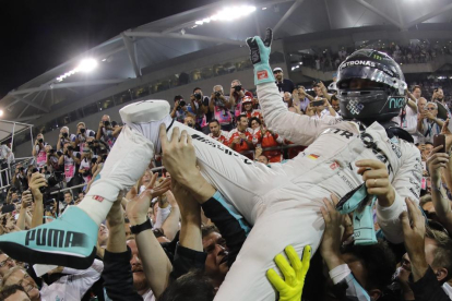 Nico Rosberg es manteado en el circuito Yas Marina después de lograr el título de campeón del mundo.