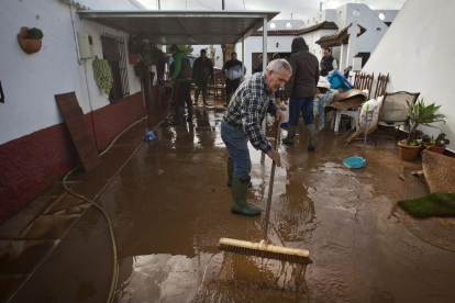 Vecinos de Conil, en Cádiz, achicando agua y fango de sus casas.