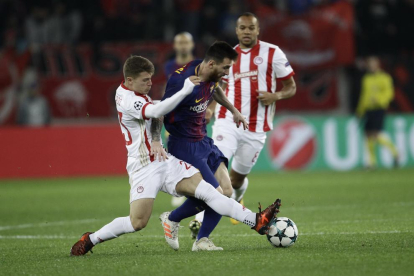 Messi intenta desbordar a dos jugadores del Olympiacos.