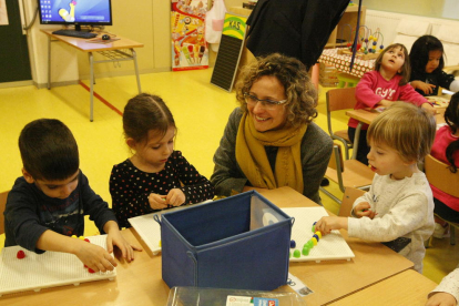 A la izquierda, la consellera, sentada junto a un alumno y al alcalde, durante su visita a la escuela del Secà de Sant Pere. A la derecha, en la escuela La Creu, de Torrefarrera.