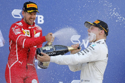 Bottas celebra el triomf al podi amb Vettel, que va ser segon.