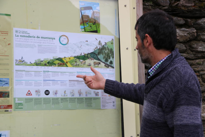 Una persona observando el cartel del Parc Natural de l’Alt Pirineu con los consejos y recomendaciones para los turistas. 