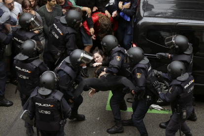 Els agents de la Policia Nacional formen un cordó policial al col·legi Ramon Llull i s’emporten una noia.