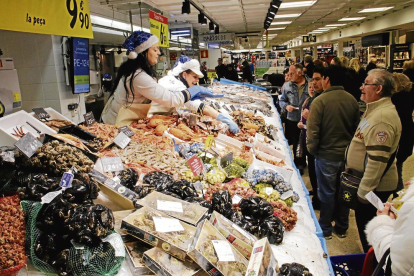 Imatge de clients lleidatans que compren peix per a la celebració de les festes nadalenques.