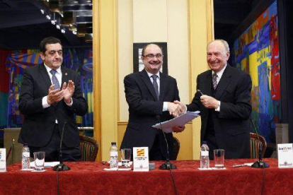 Javier Lambán y Jaume Alsina se dan la mano tras la firma del convenio ayer en Zaragoza.
