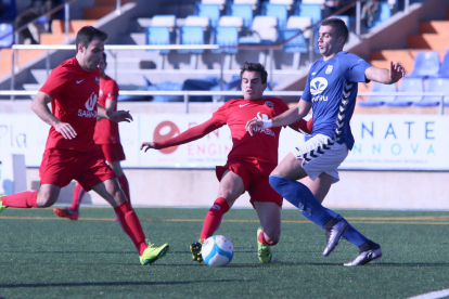 Dos futbolistes de l’Alpicat lluiten per la pilota davant d’un jugador de la Rapitenca, en una acció del partit d’ahir.