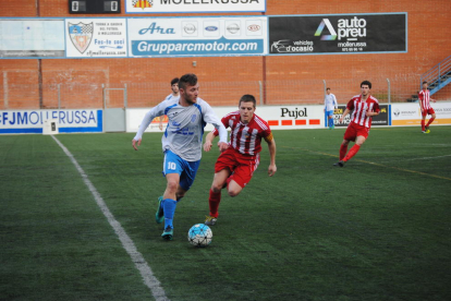 El local Edu Raya condueix la pilota davant l’oposició d’un jugador rival durant una ocasió del partit.