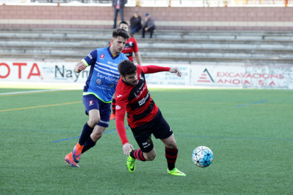 El jugador de l’EFAC Almacelles Òscar Canadell supera la pressió d’un contrari amb un company al fons.