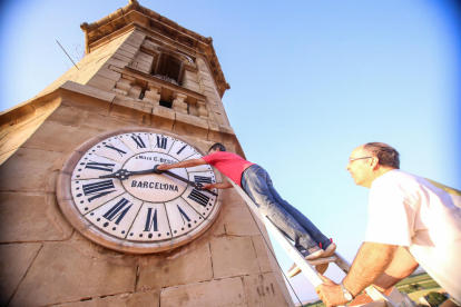 Jaume Espart (en la escalera) y Ramon Solé, dando los últimos retoques al reloj del campanario.