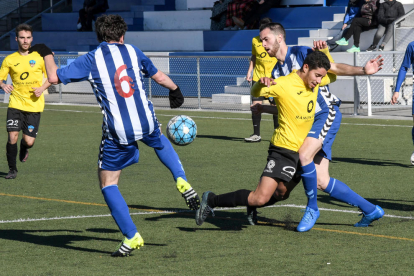 Un jugador del Lleida Esportiu B, ayer de amarillo, cae ante la presión de dos rivales.