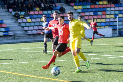 Un jugador de l’EFAC Almacelles controla la pilota davant de la pressió d’un jugador del Santboià.
