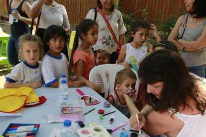 Varios niños esperan para participar en el taller de maquillaje.