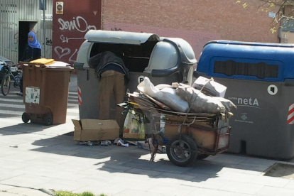 Un home buscant en un contenidor a Lleida.