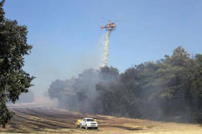 Un helicòpter llança aigua en l’incendi de Pujalt, a prop d’Estaràs.