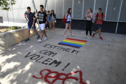 Alumnes, ahir, al costat d’una pintada apareguda davant de l’institut Samuel Gili i Gaya.