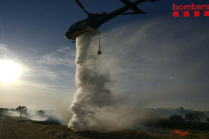 Un helicòpter, ahir, durant l’extinció del foc a les Garrigues.