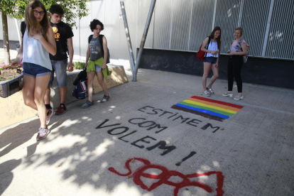 Alumnes miren una pintada a l’institut Gili i Gaya contra els comentaris homòfobs d’un docent.