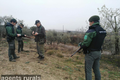 Un grup de tres agents rurals, amb armilles antibales i una carrabina en un control de caça.