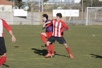 Un jugador local y otro visitante luchando por un balón en Vilanova. 
