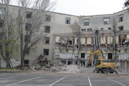 El deterioro del edificio antes del derribo, tras 23 años de abandono, era muy visible con cristales y puertas rotas y graffitis. A la derecha, las fases iniciales de la demolición. 