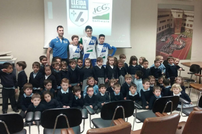 Marc Soler y tres jugadores del club posan con alumnos de preescolar de Lestonnac.