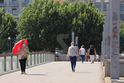 Peatones en una jornada de calor en Lleida.