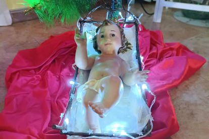 el nen jesus a la cuna al peu del arbre de nadal