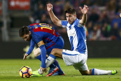 Leo Messi es entrado con fuerza por un defensa del Leganés.